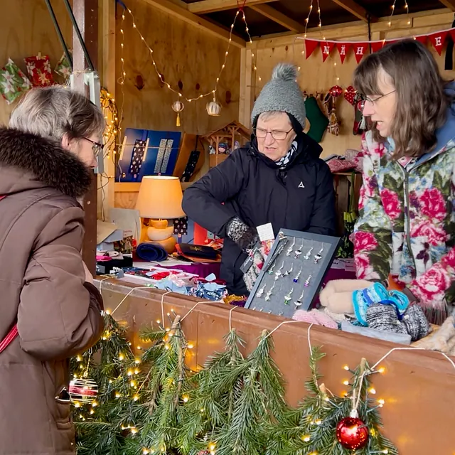 Eine Frau schaut sich die Auslagen in der Geschenkebude an