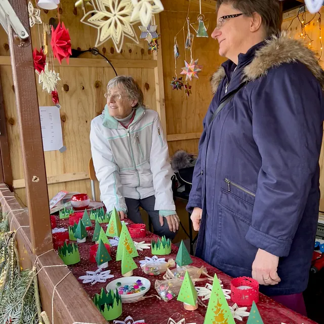 Zwei Frauen hinter der Auslage von selbstgebastelten Weihnachtsdekorationen