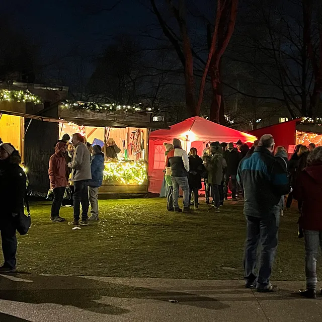 Viele Menschen vor den Buden bei Dunkelheit