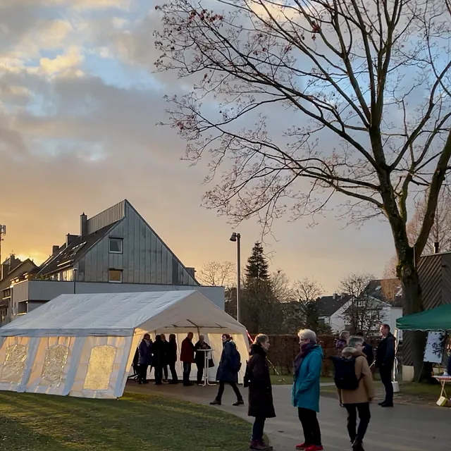 Viele Menschen auf der Wiese vor der Immanuel-Kirche in der gelben Wintersonne